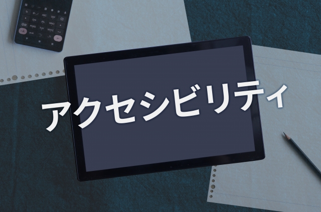 Tablet on a desk with the Japanese word 'アクセシビリティ' across the screen, signaling accessibility.